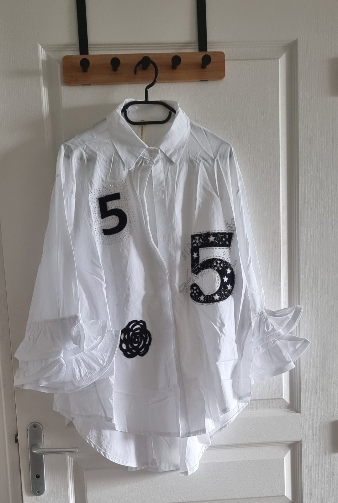 Chemise blanche avec des empiècements en feutrine noire et ornée de strass argentés